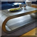 F04. Metal wrapped oval shaped industrial style coffee table. 18”h x 56”w x 24”d 